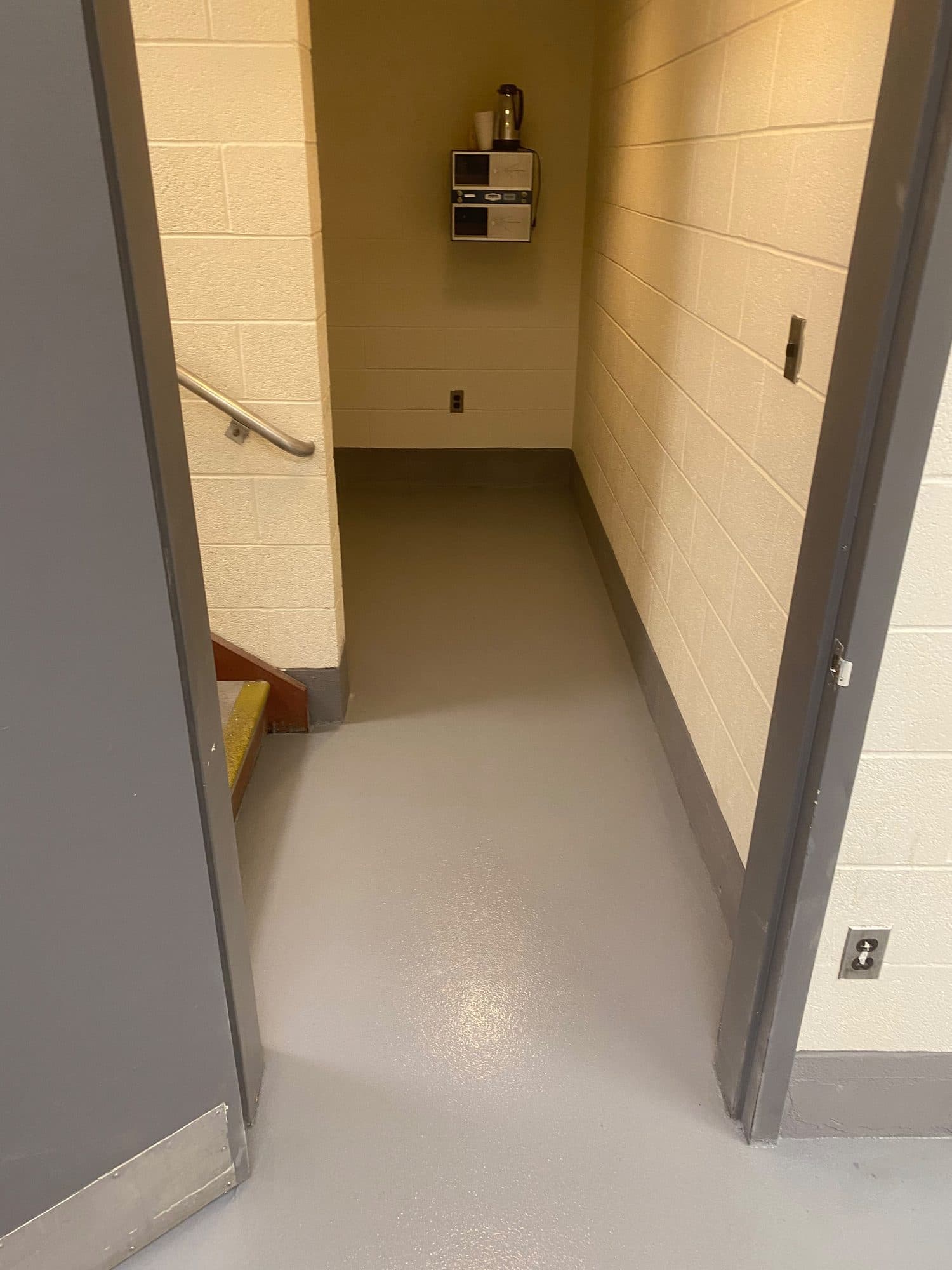 Quartz system floor with integral cove base at a stairwell entry