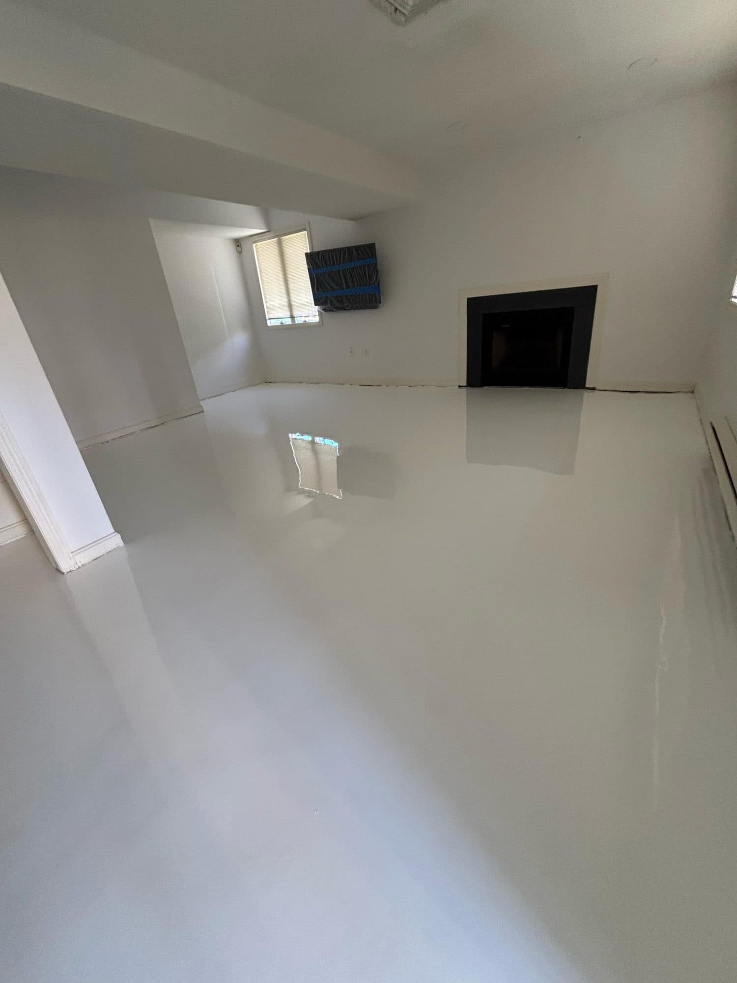High-gloss white solid color epoxy floor in a residential room
