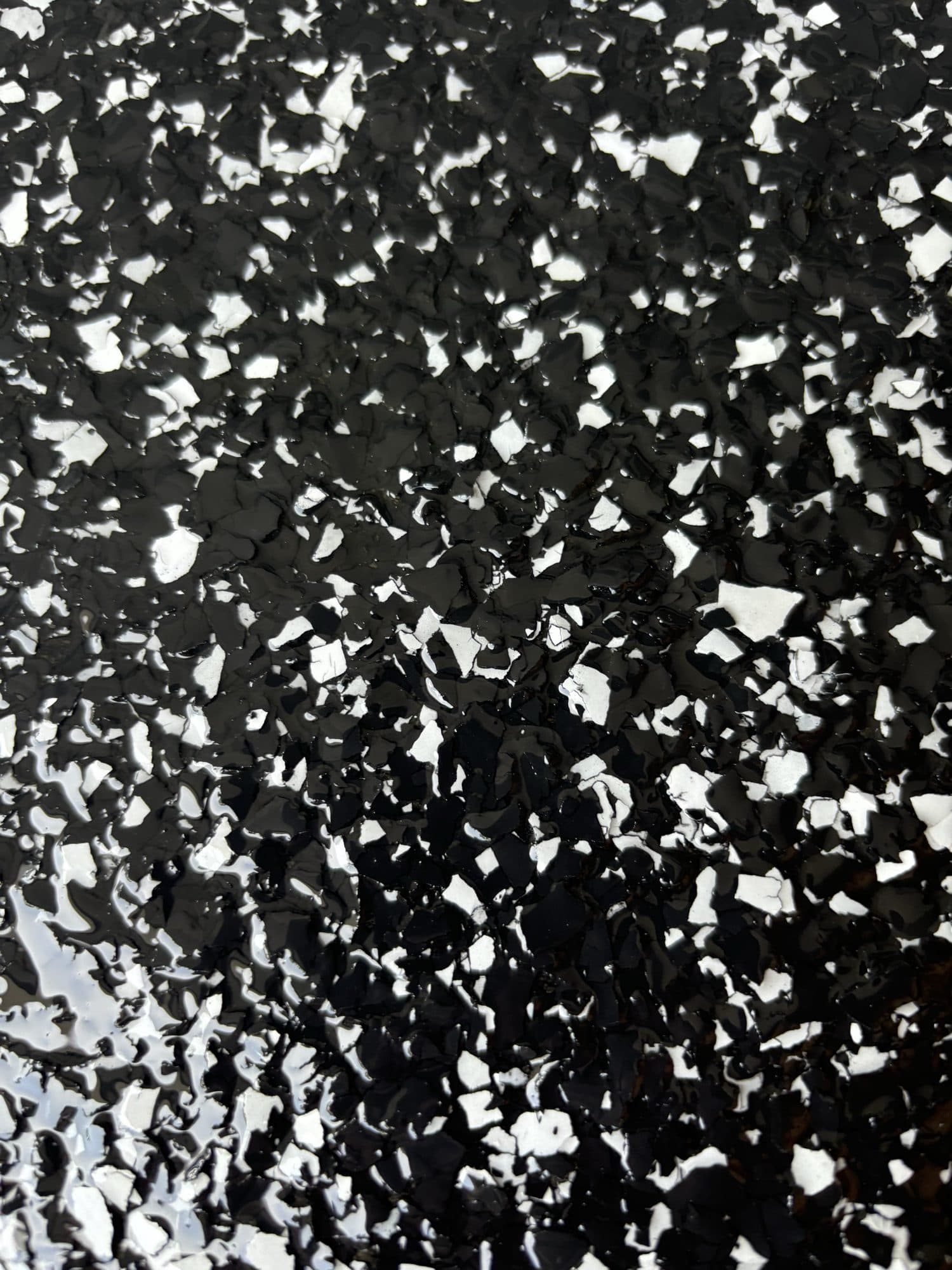 Close-up of black epoxy flake texture with white chips