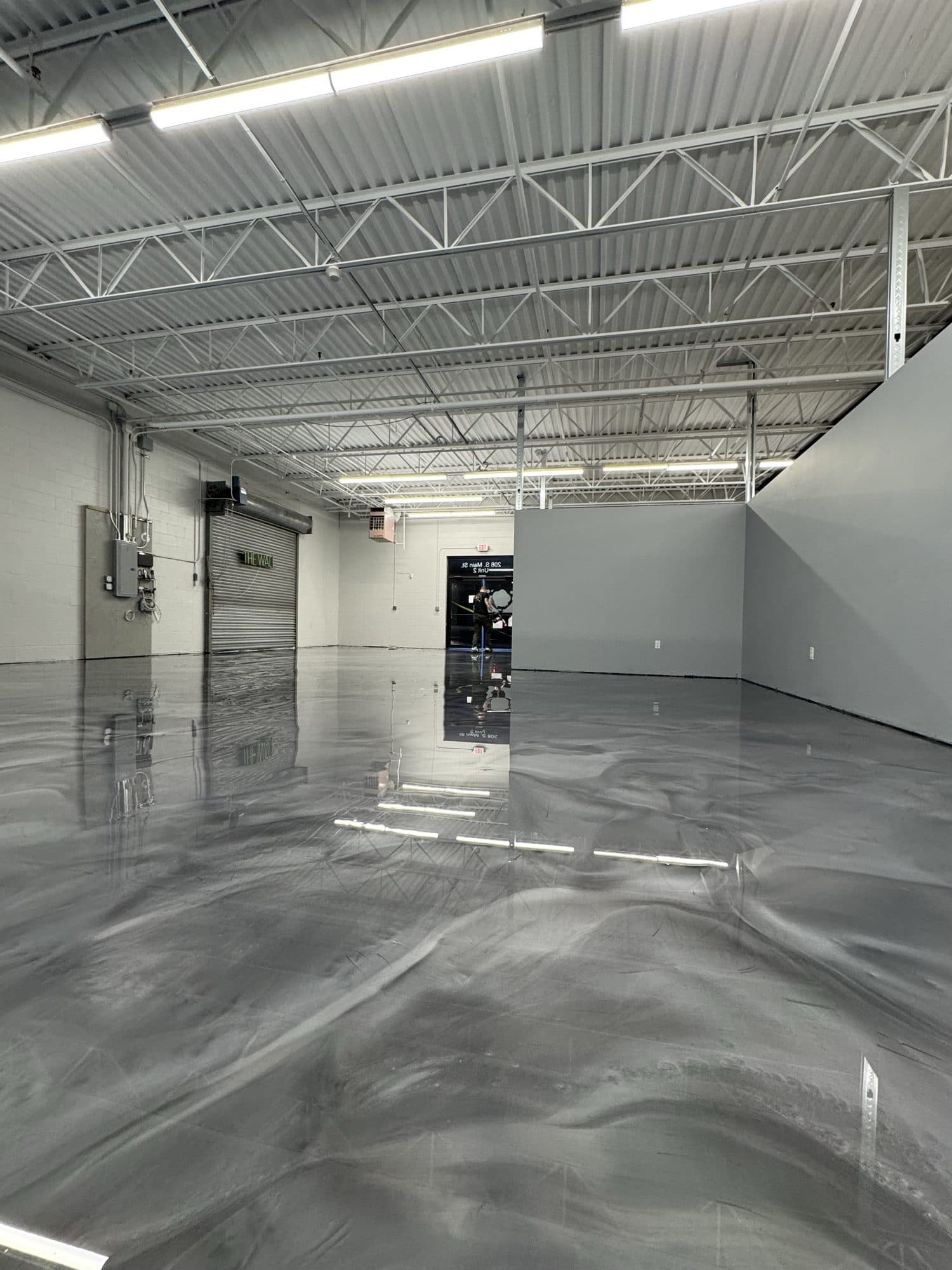 Glossy metallic epoxy floor reflecting ceiling lights