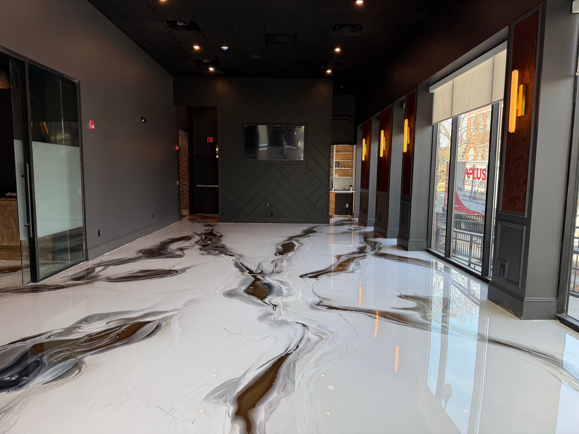 Metallic epoxy floor in a dark premium commercial interior
