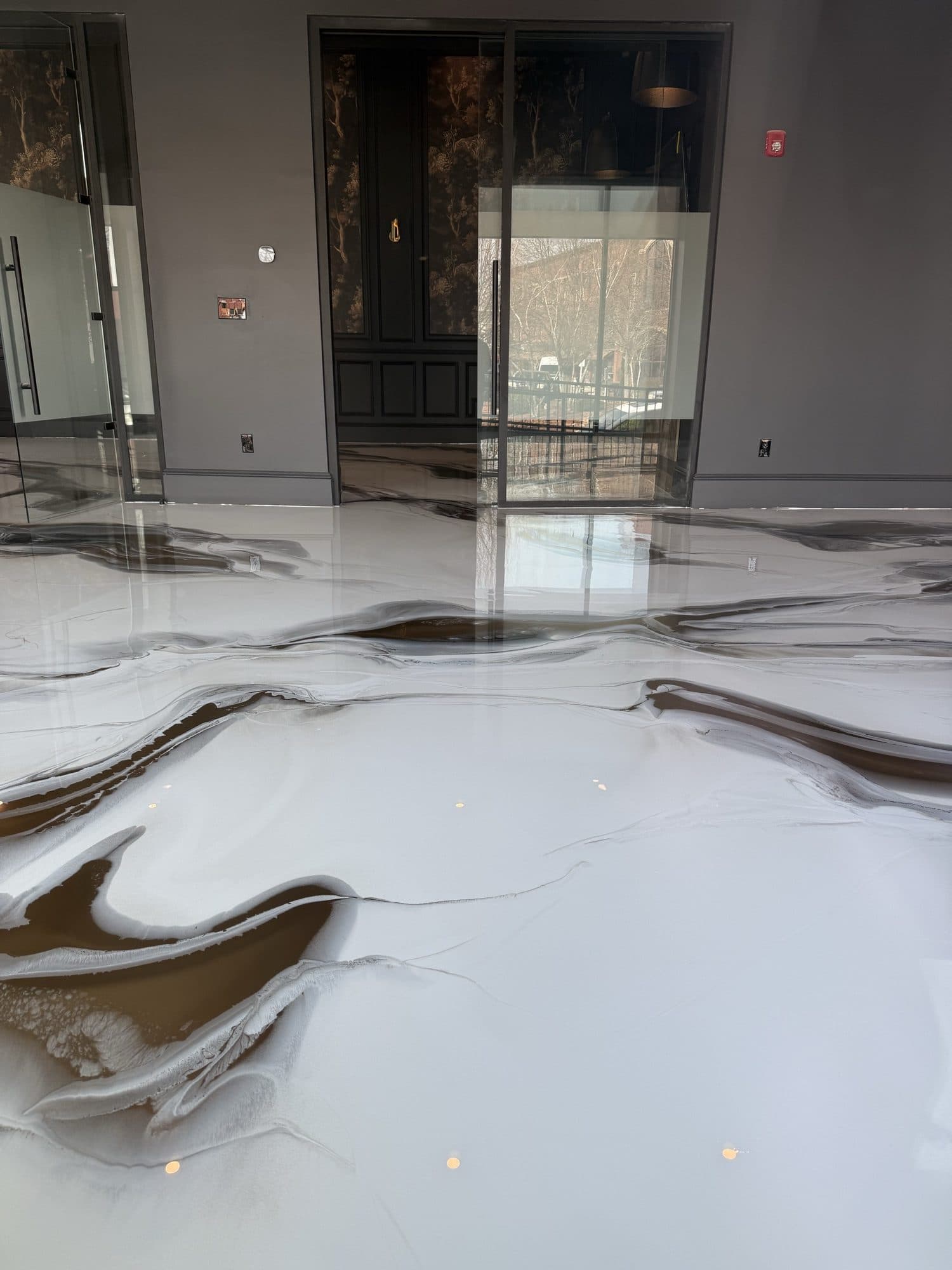 High-gloss metallic epoxy floor reflecting the room